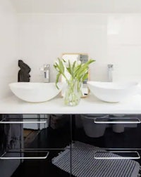 a black and white bathroom with two sinks and a mirror