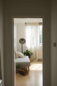 a doorway leading into a room with a bed and a window