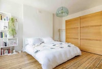 a bedroom with wooden floors and a bed