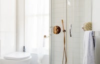 a white bathroom with a toilet and shower