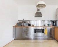 a kitchen with stainless steel appliances and wooden floors